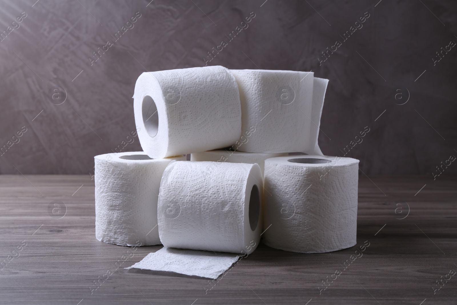 Photo of Soft toilet paper rolls on wooden table