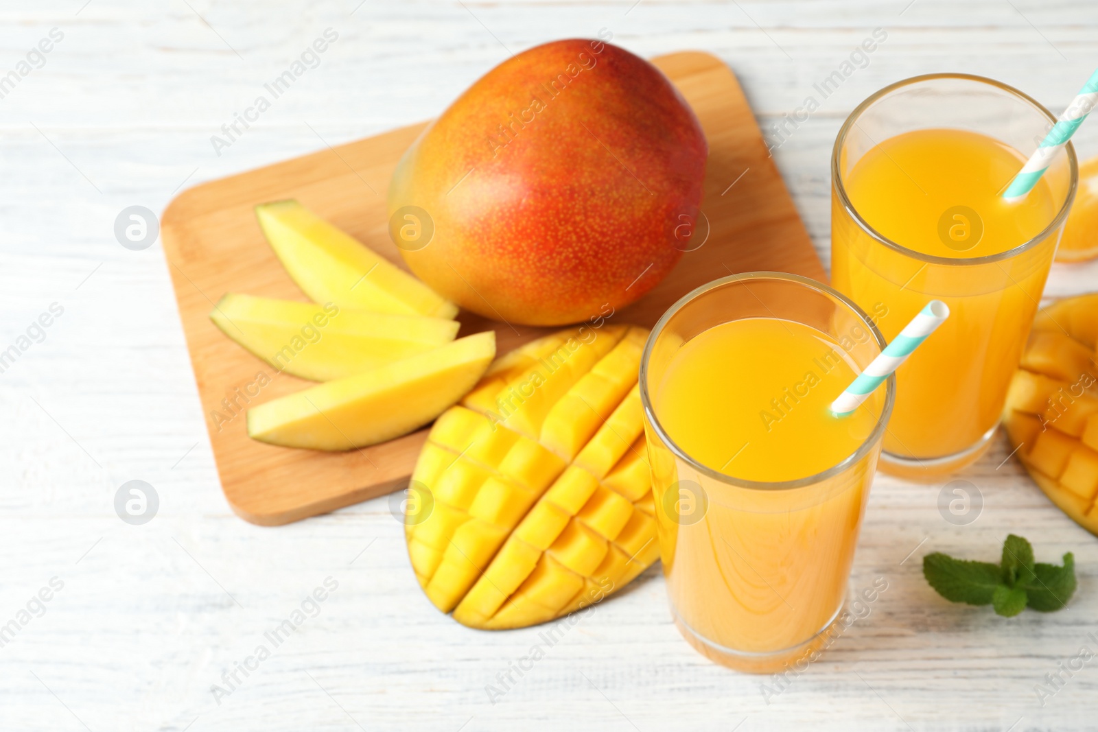 Photo of Tasty mango drink and fresh fruits on wooden table