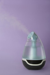 Photo of New modern air humidifier on violet background
