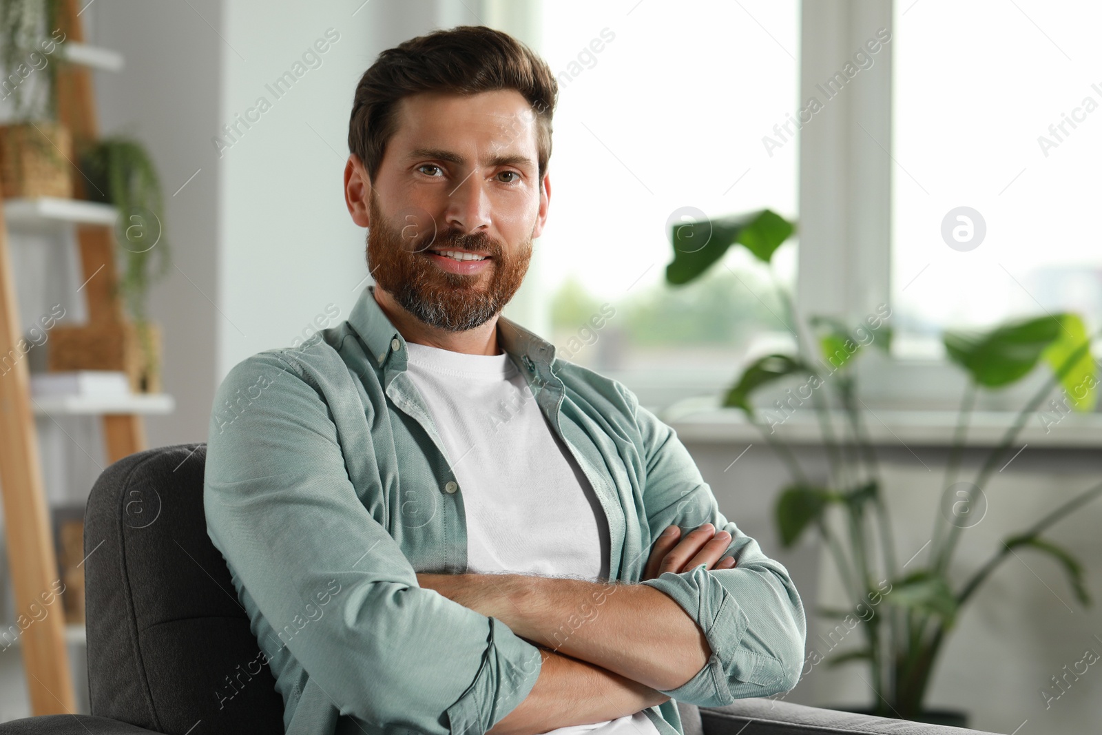 Photo of Portrait of handsome bearded man at home, space for text