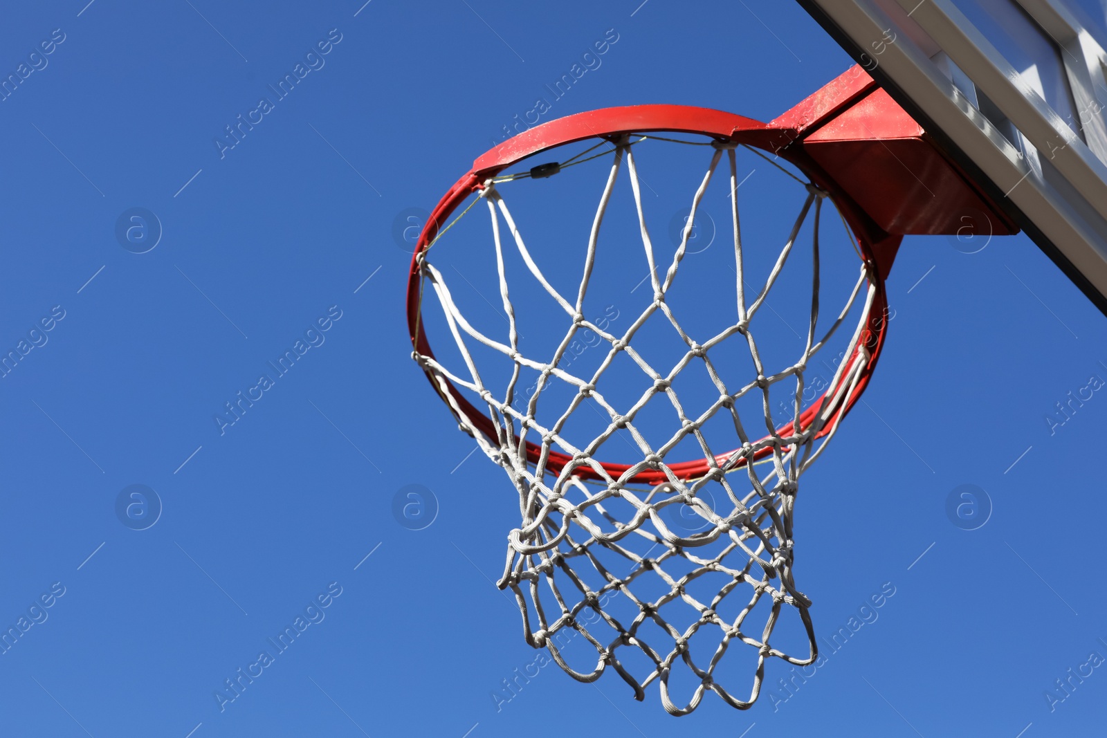 Photo of Basketball hoop with net outdoors on sunny day