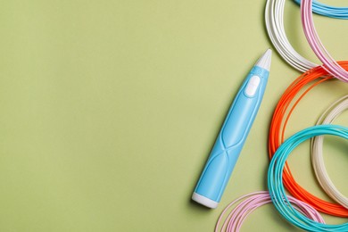 Stylish 3D pen and colorful plastic filaments on olive background, flat lay. Space for text