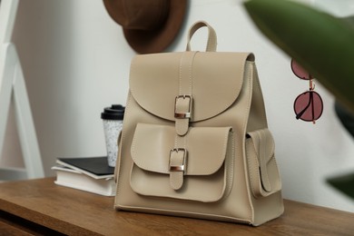 Photo of Stylish urban backpack on wooden table in hallway