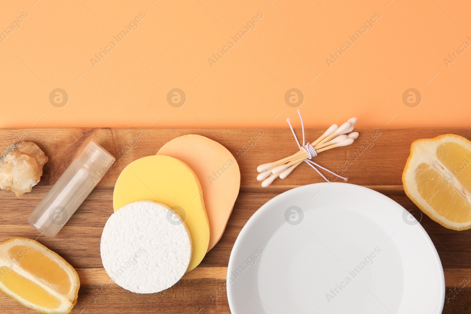 Photo of Lemon face cleanser. Fresh citrus fruits and personal care products on pale orange background, top view with space for text