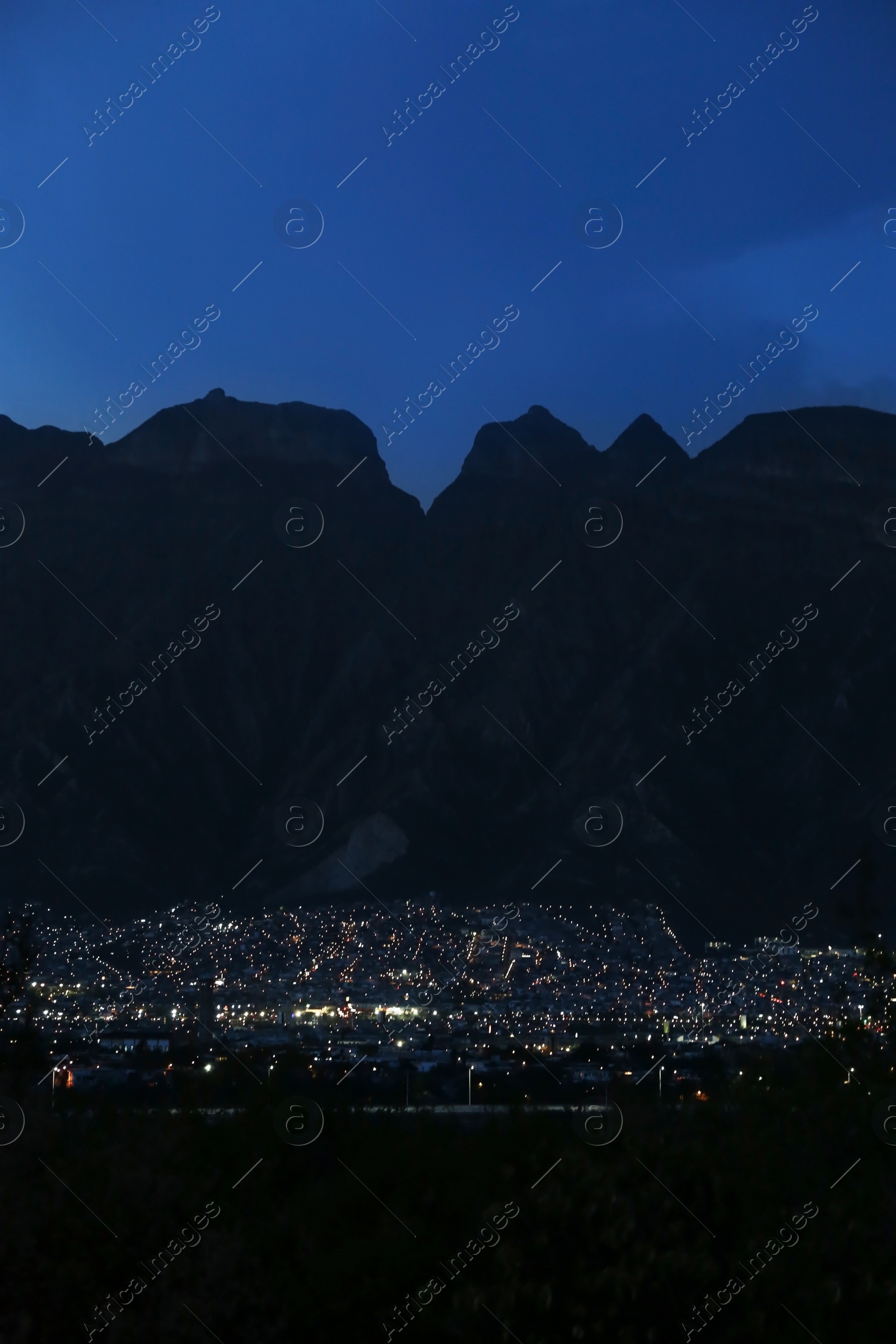 Photo of Picturesque view of beautiful city near mountains at night