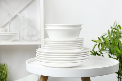 Photo of Different clean plates on table in kitchen