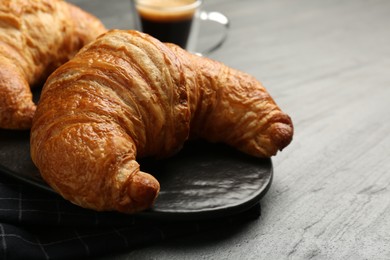 Photo of Delicious fresh croissants on gray table, closeup