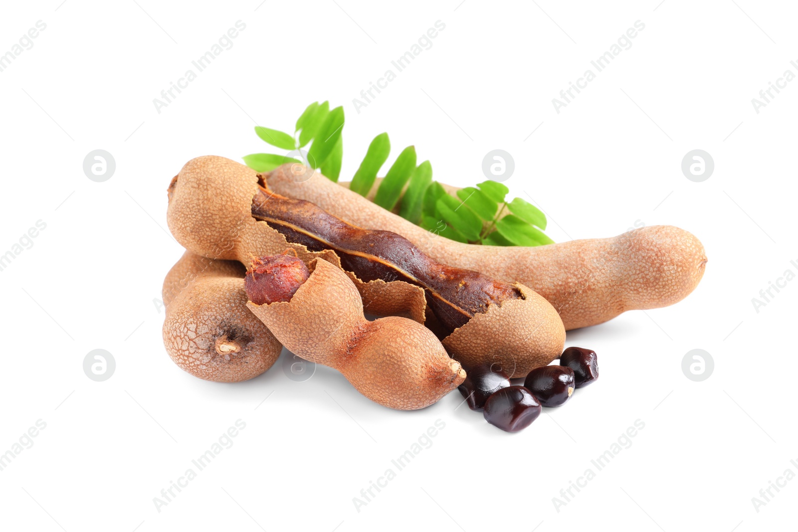 Photo of Delicious ripe tamarinds with leaves and seeds on white background. Exotic fruit