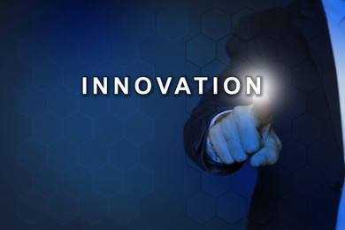Image of Man touching word Innovation on digital screen against dark blue background, closeup