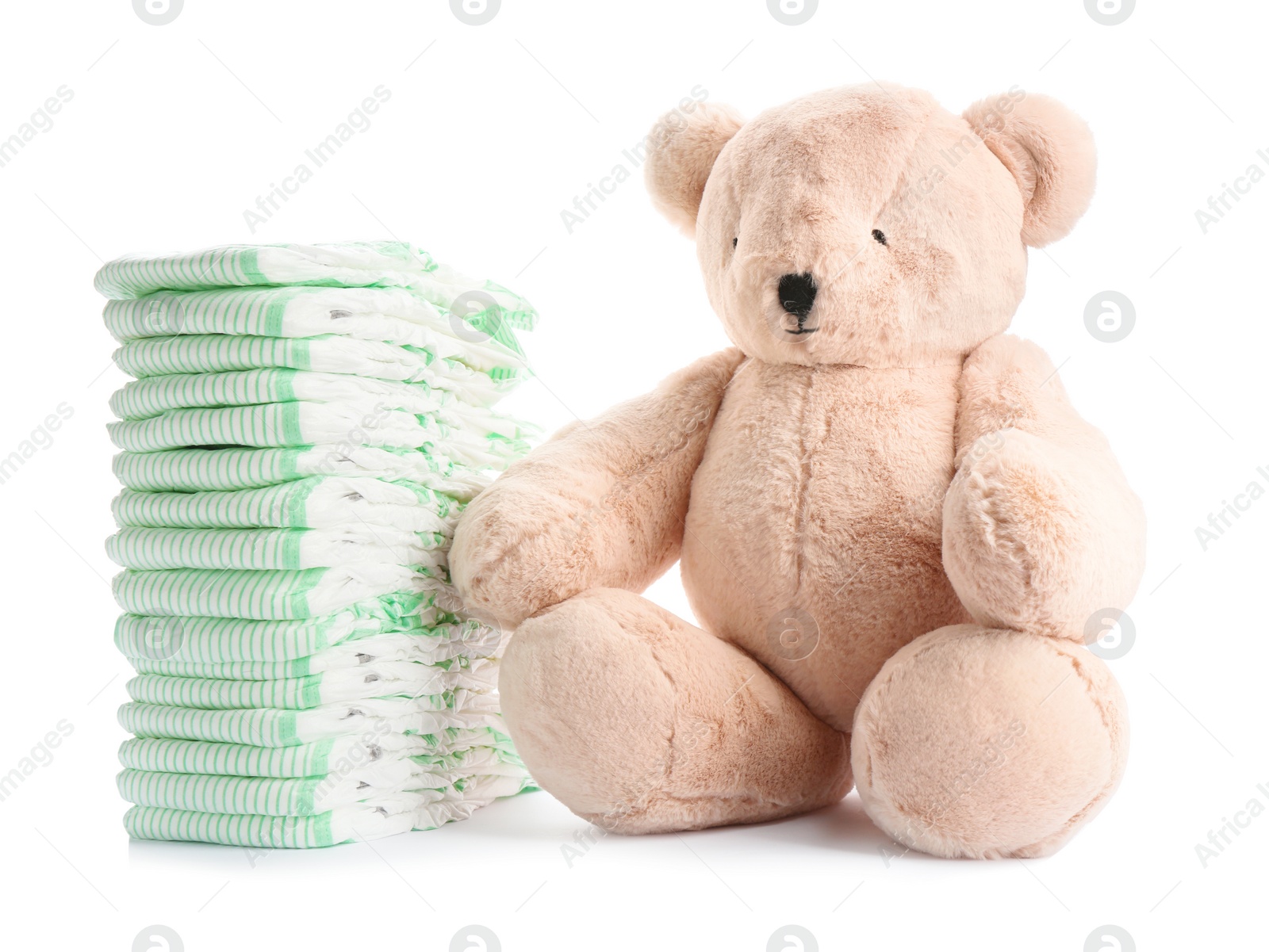 Photo of Stack of diapers and teddy bear on white background. Baby accessories