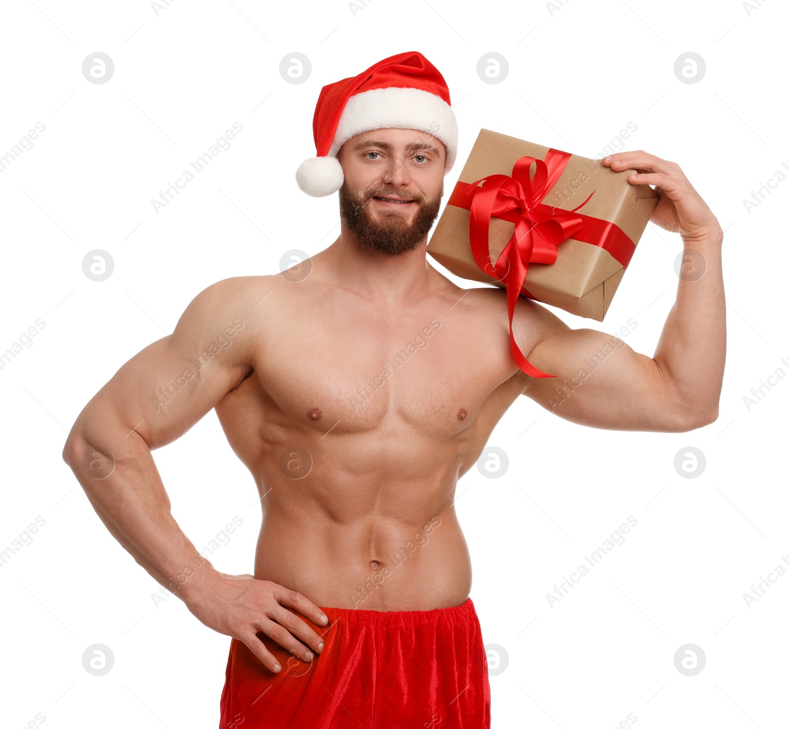 Photo of Attractive young man with muscular body in Santa hat holding Christmas gift box on white background