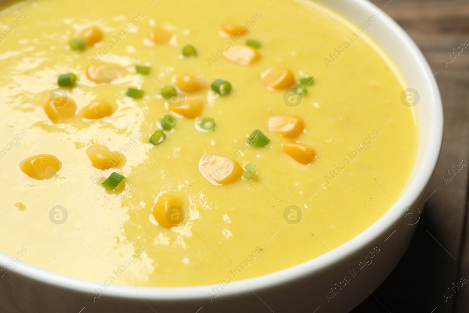 Photo of Delicious creamy corn soup on table, closeup