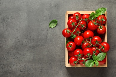 Photo of Crate with fresh cherry tomatoes on stone background, top view. Space for text