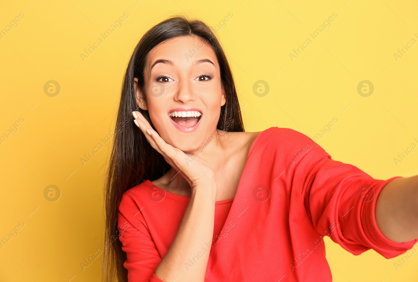 Photo of Young beautiful woman taking selfie against color background