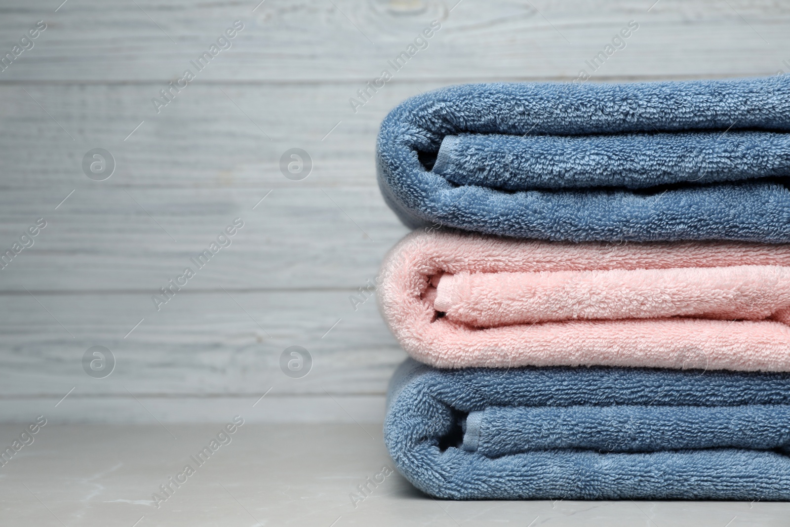 Photo of Stack of fresh towels on table. Space for text