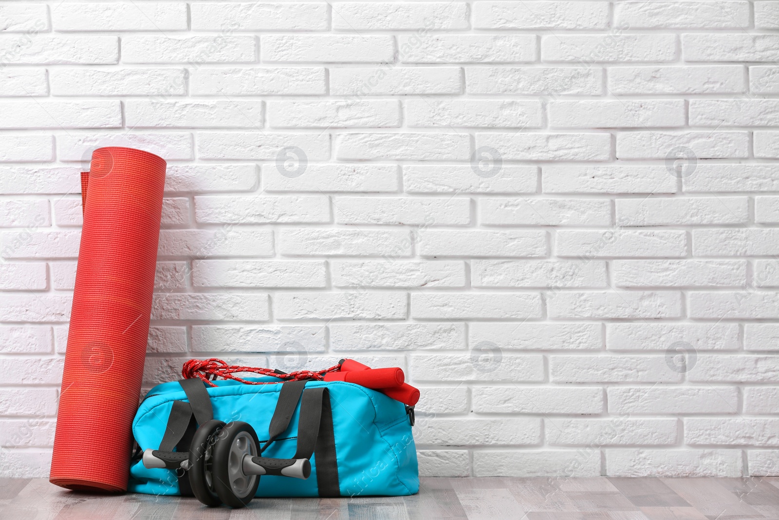 Photo of Set of fitness equipment on floor near brick wall. Space for text