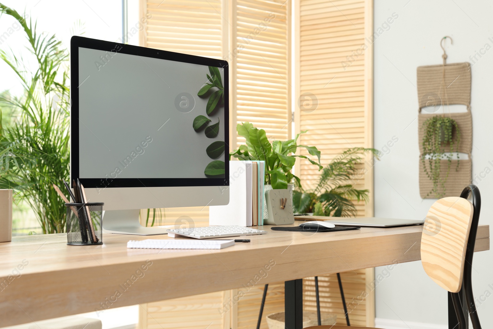 Photo of Comfortable workplace with computer in light room. Interior design