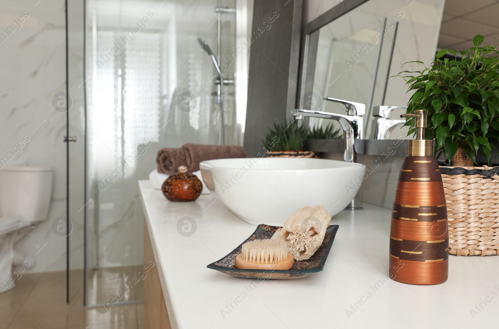 Photo of Soap dispenser, loofah and brush on table in bathroom