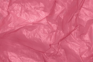 Photo of Crumpled red plastic bag as background, top view