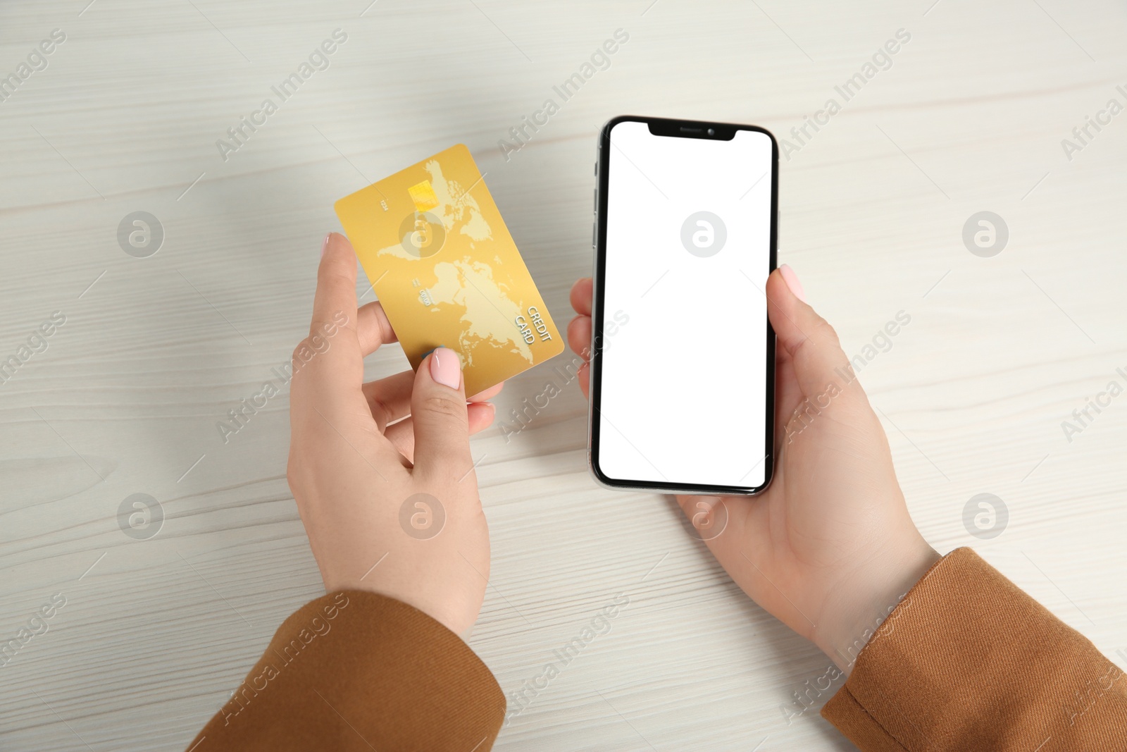 Photo of Online payment. Woman using credit card and smartphone with blank screen at white wooden table, top view