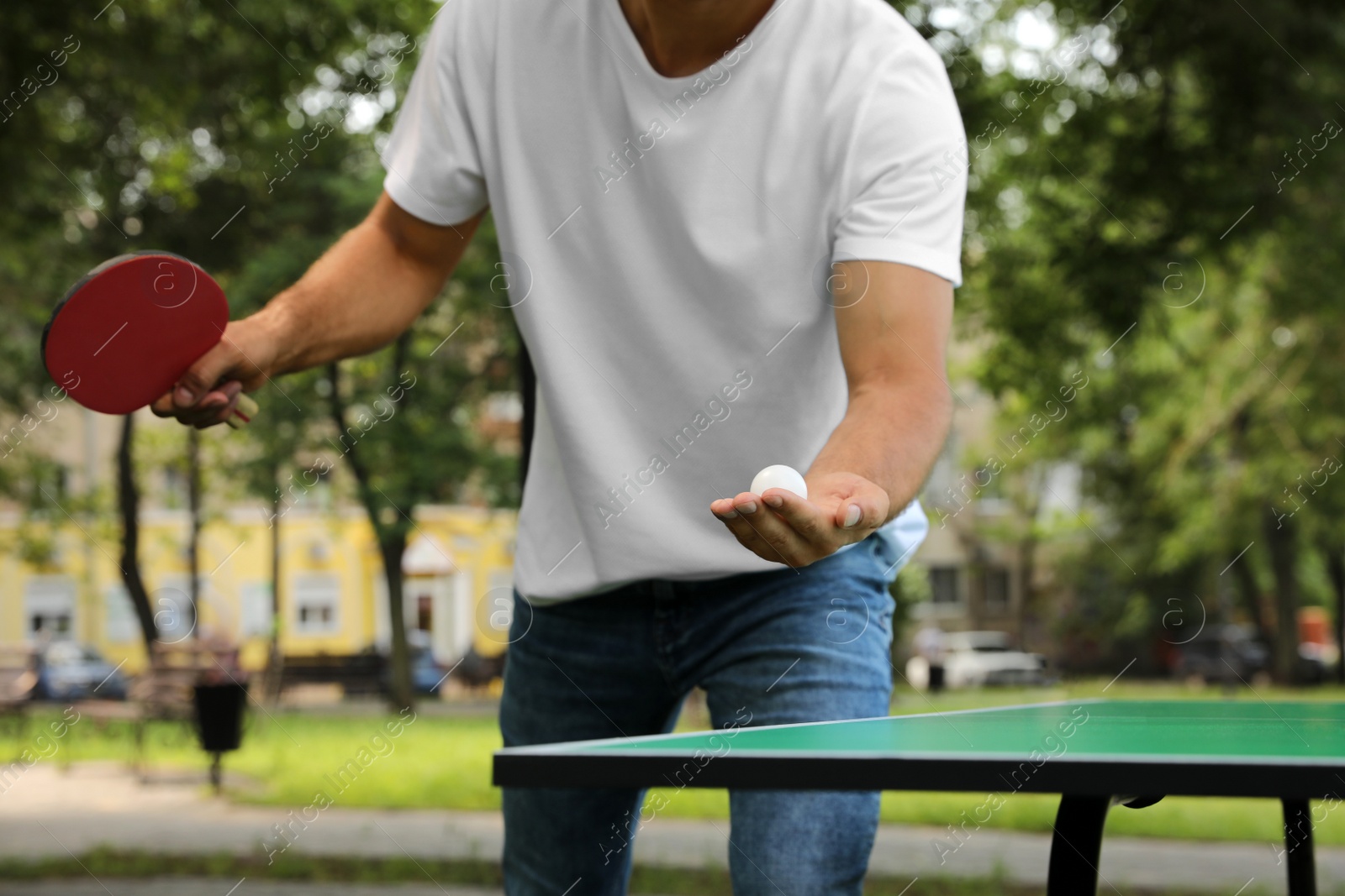 Photo of Man playing ping pong in park, closeup