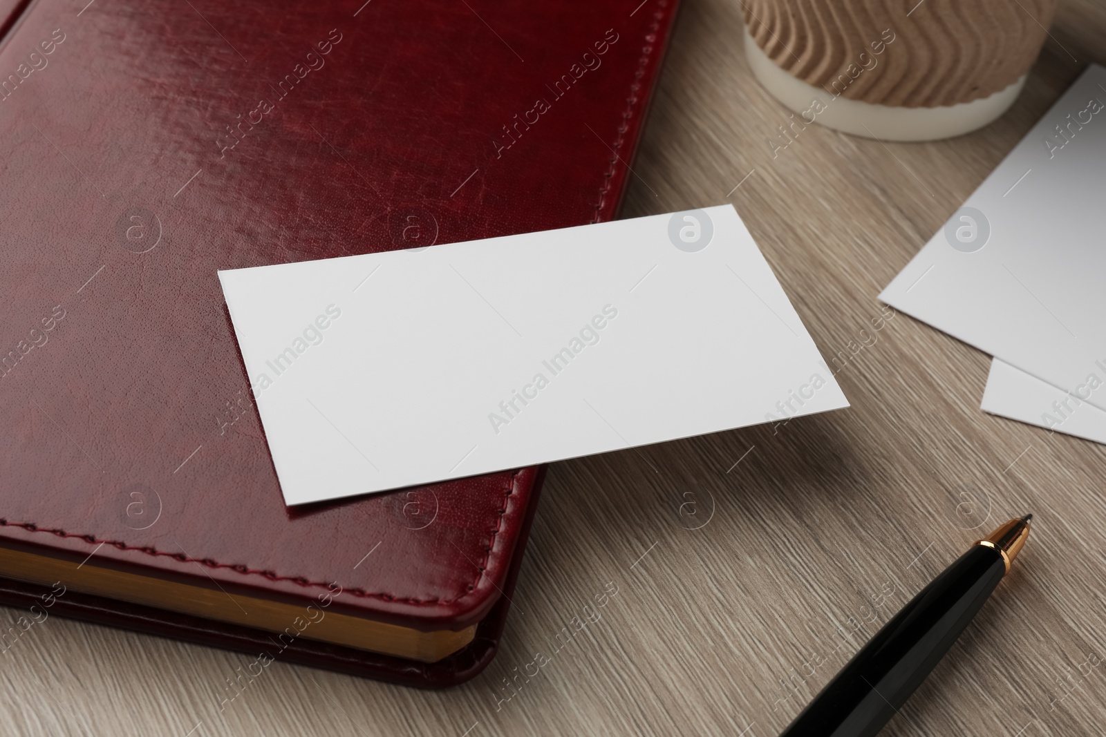 Photo of Blank business cards and notebook on wooden table, closeup. Mockup for design