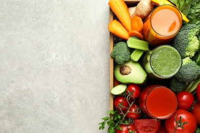 Photo of Delicious vegetable juices and fresh ingredients on light grey table, top view. Space for text