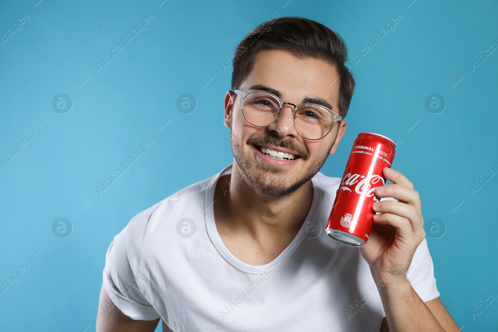 Photo of MYKOLAIV, UKRAINE - NOVEMBER 28, 2018: Young man with Coca-Cola can on color background