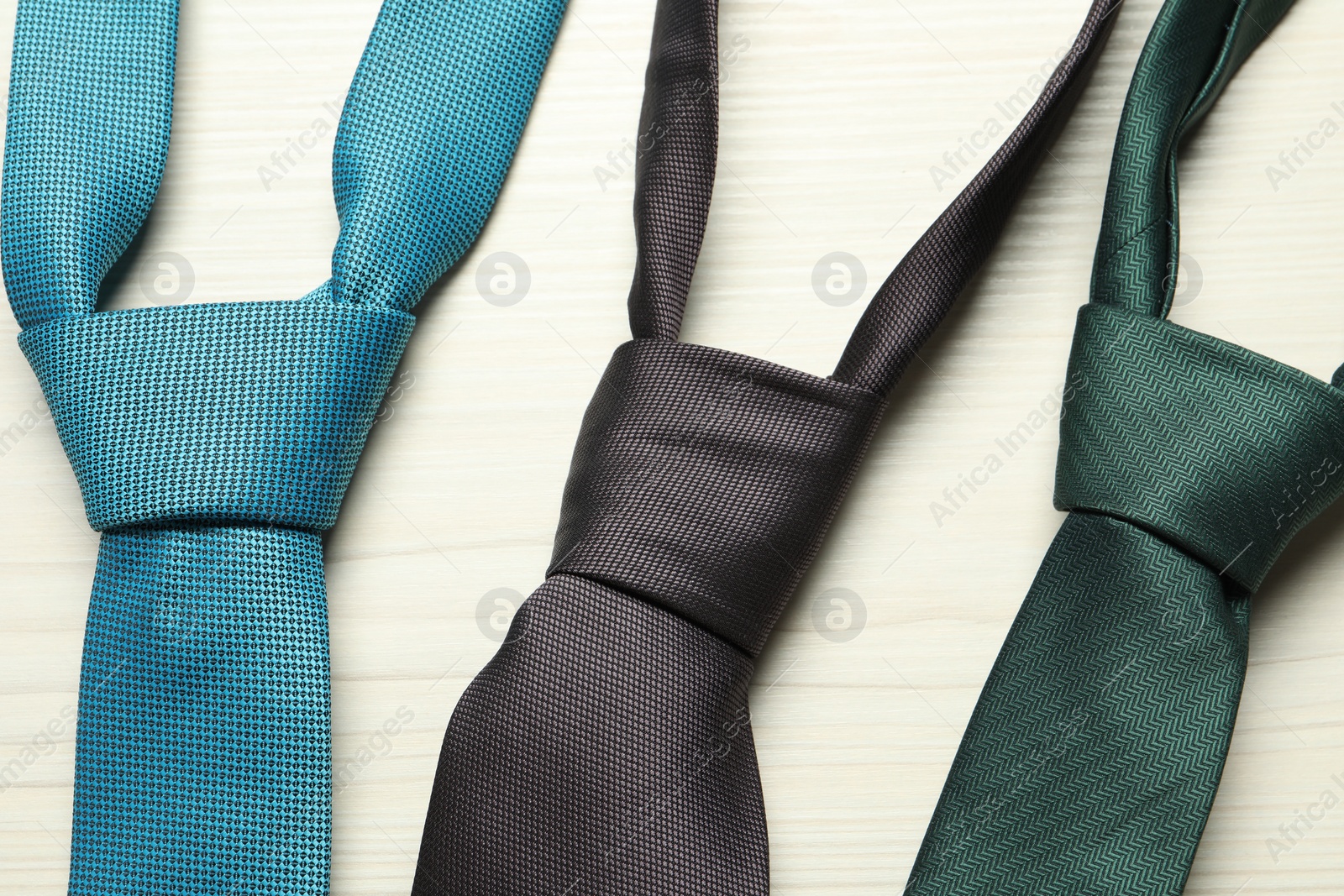 Photo of Different neckties on white wooden table, flat lay