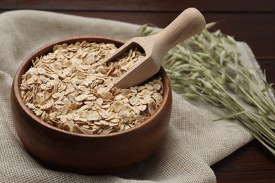 Photo of Bowl and scoop with oatmeal on table, closeup