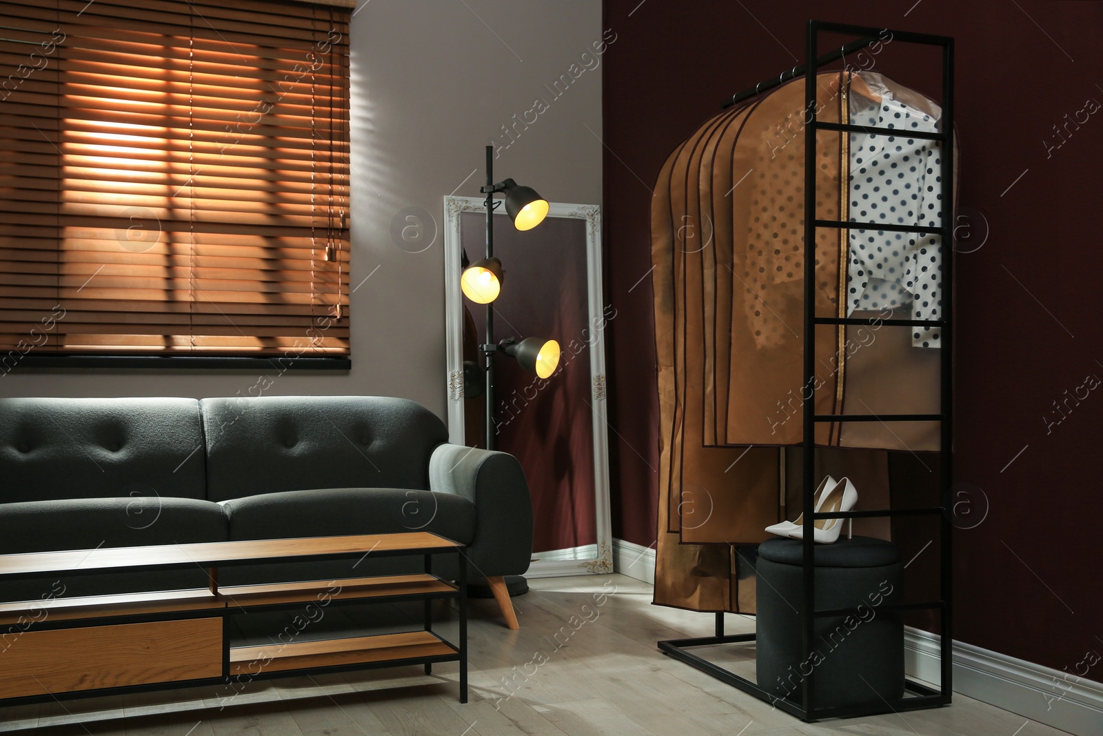 Photo of Garment bags with clothes hanging on rack in room