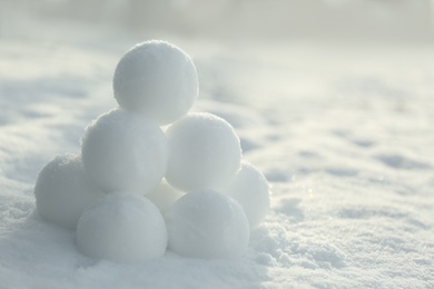 Photo of Pyramid of perfect snowballs on snow outdoors, closeup