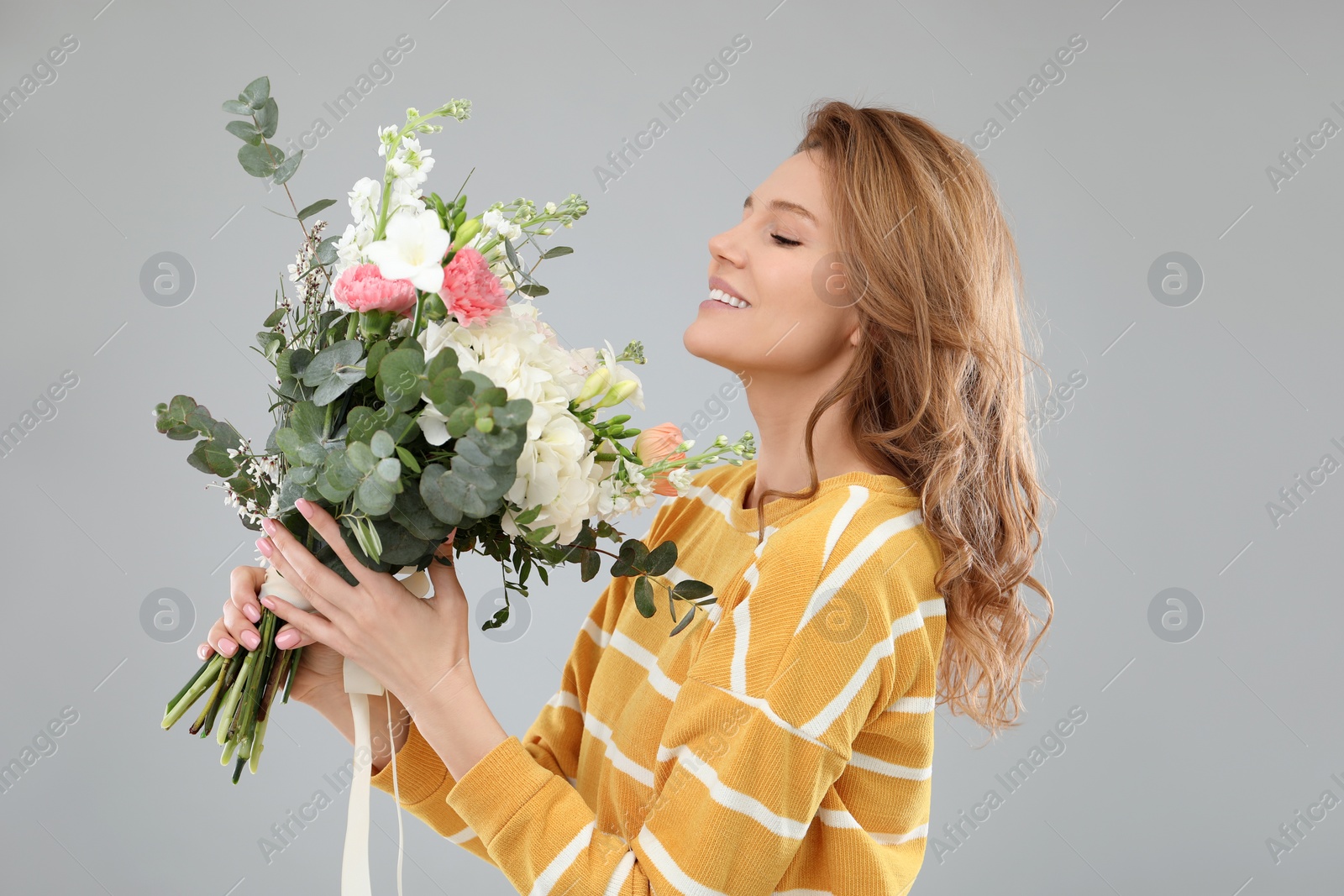 Photo of Beautiful woman with bouquet of flowers on grey background