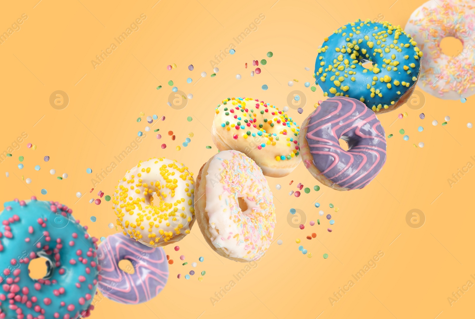 Image of Many sweet tasty donuts with sprinkles falling on pale orange background