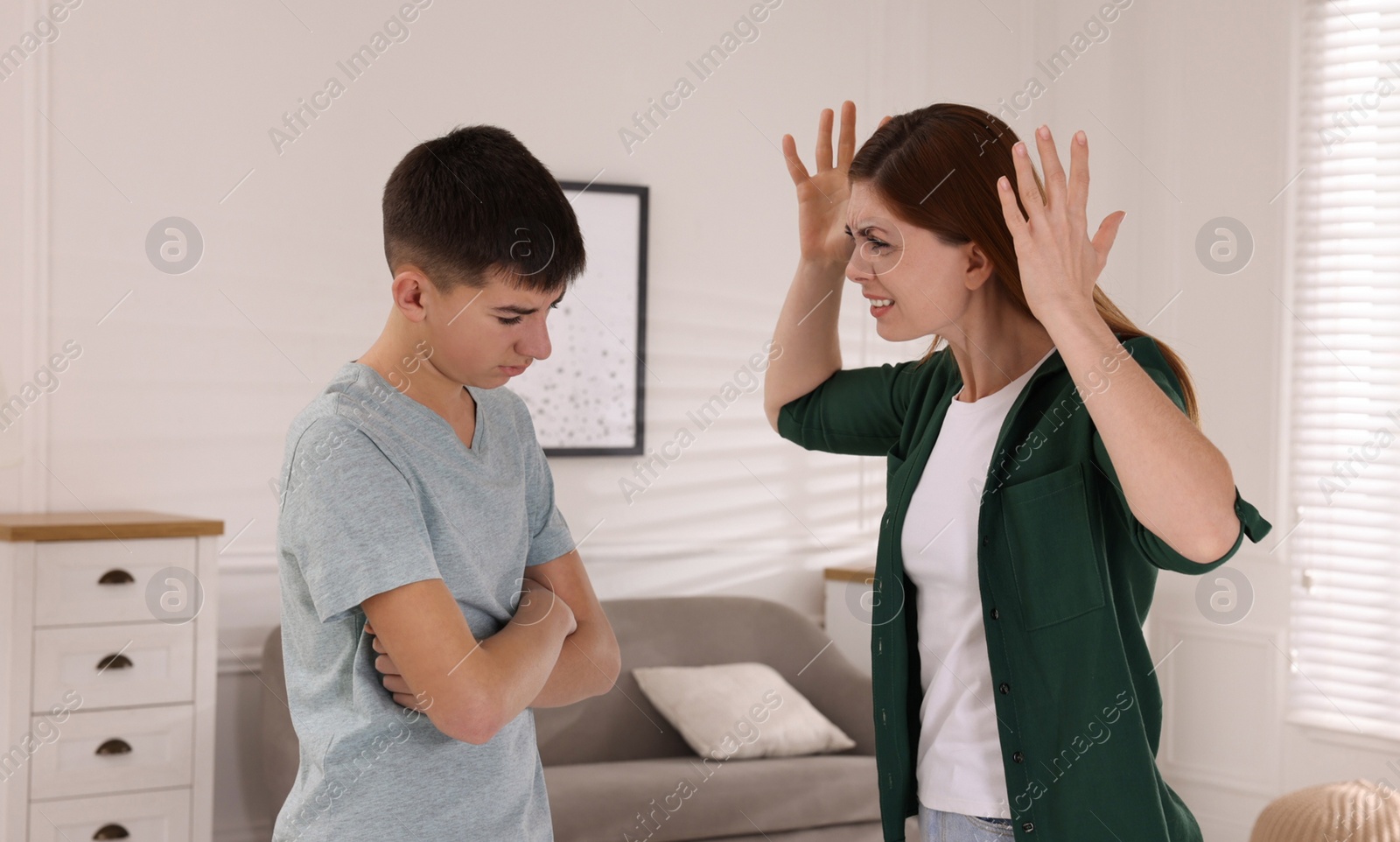 Photo of Mother scolding his son at home. Teenager problems