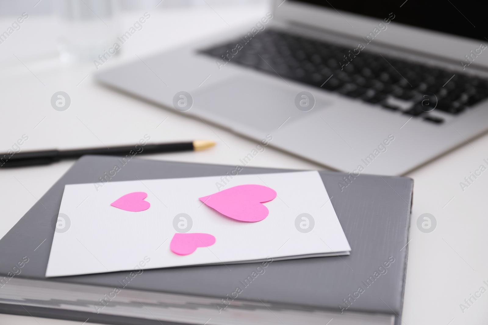 Photo of Greeting card with hearts at workplace. Valentine's Day celebration