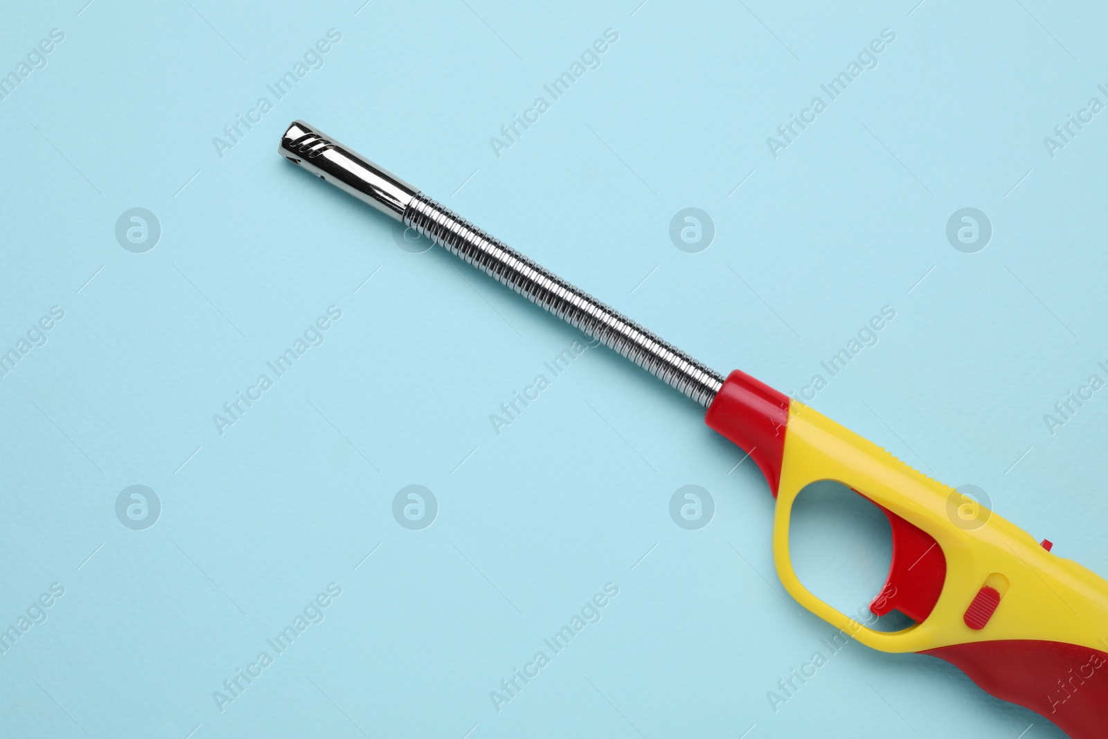 Photo of One gas lighter on light blue background, top view. Space for text