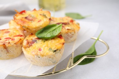 Photo of Freshly baked bacon and egg muffins with cheese on light gray table, closeup. Space for text