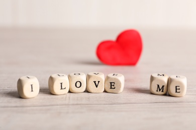 Phrase I Love Me made of small cubes on white table