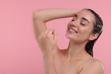 Photo of Beautiful happy woman washing hair on pink background. Space for text