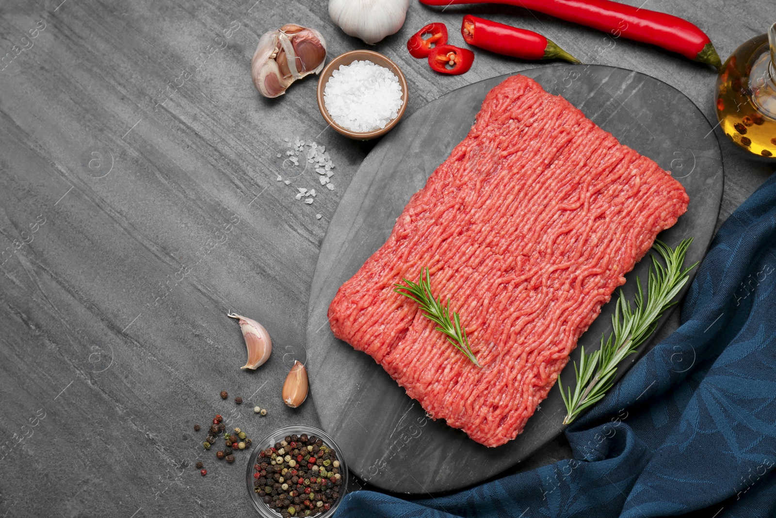 Photo of Raw fresh minced meat and ingredients on black wooden table, flat lay. Space for text