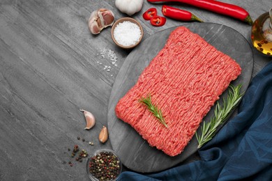 Photo of Raw fresh minced meat and ingredients on black wooden table, flat lay. Space for text