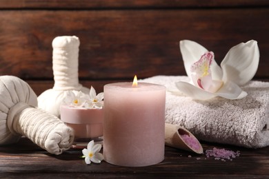 Photo of Composition with spa supplies and flowers on wooden table