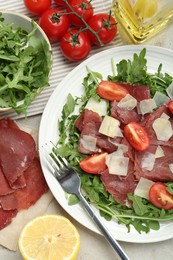 Photo of Flat lay composition with delicious bresaola salad on light grey table