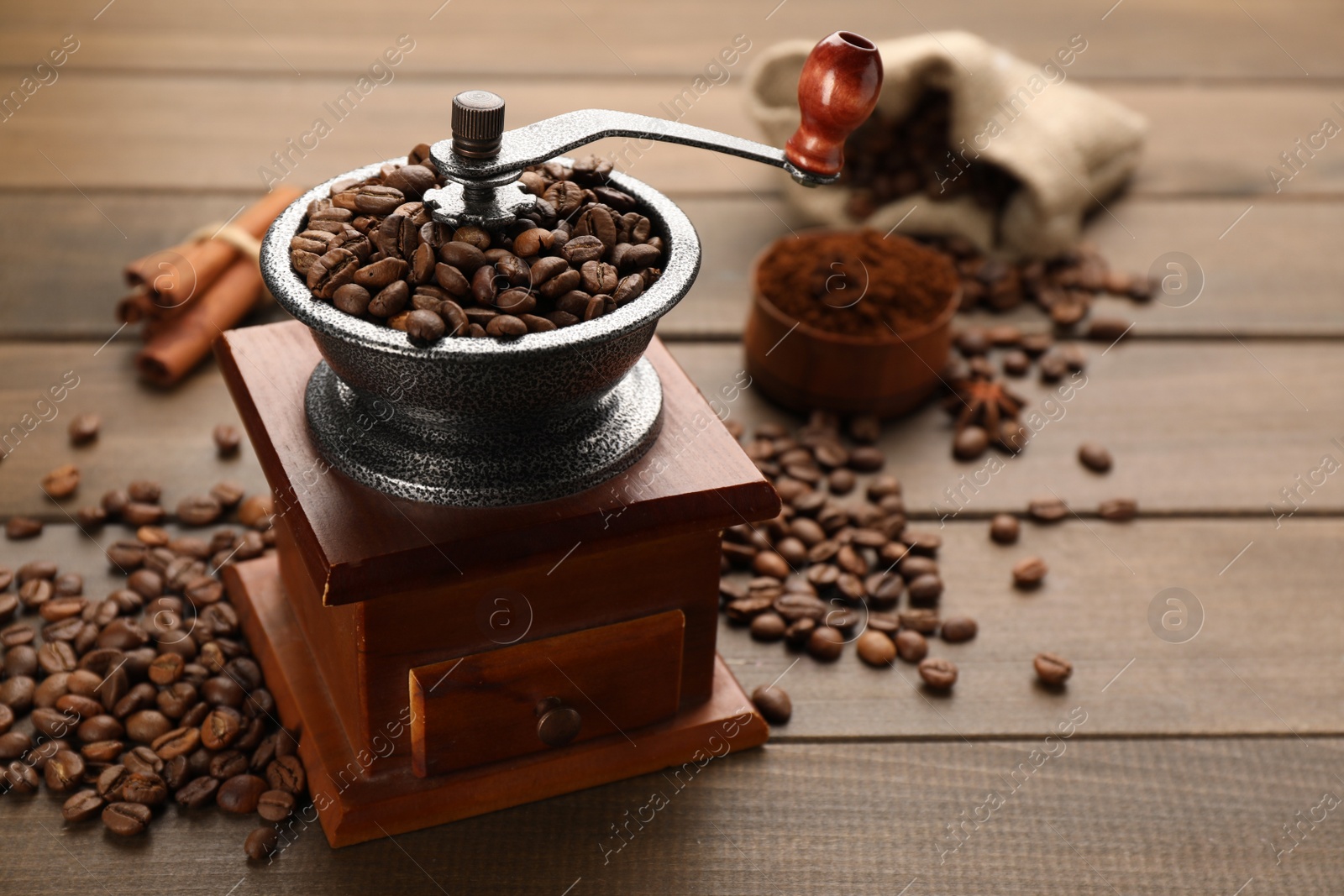 Photo of Vintage manual coffee grinder with beans on wooden table