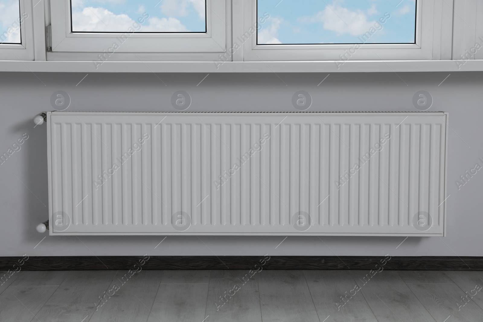 Photo of Modern radiator under window in office. Interior design