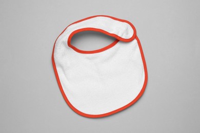 Photo of New baby bib on grey background, top view. First food