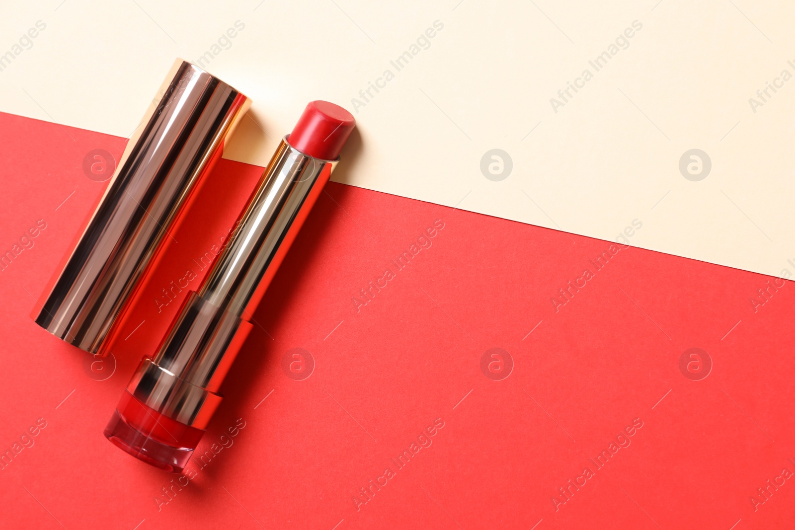 Photo of Red lipstick on color background, top view. Space for text