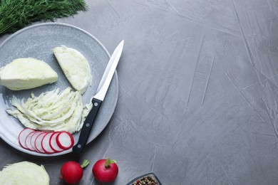 Photo of Cut cabbage and radish on grey table, flat lay. Space for text
