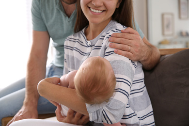 Happy couple with their newborn baby at home, closeup